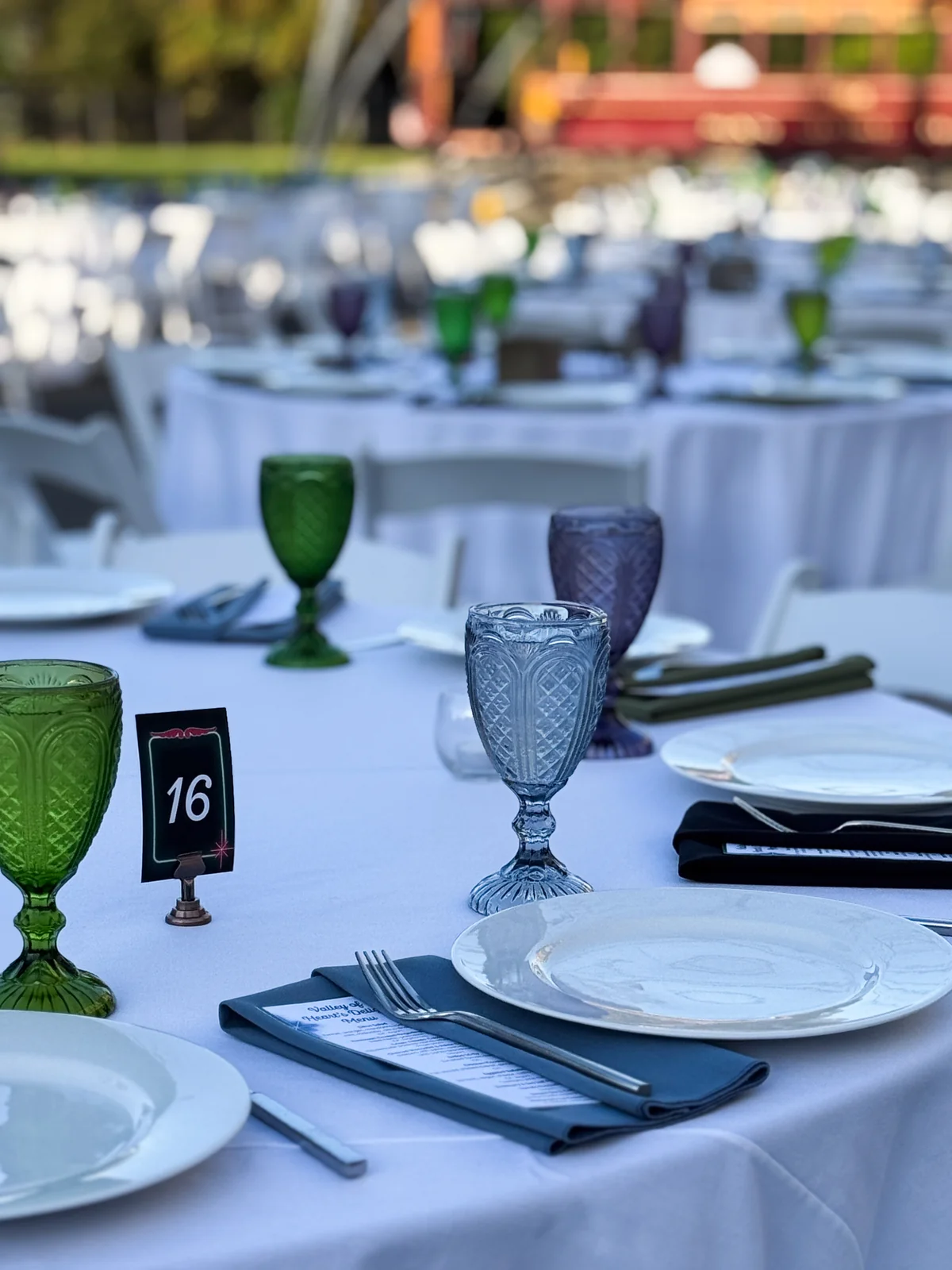 Elegant table setting with colored goblets and table numbers at the Legacies Under the Lights fundraising gala at History Park San Jose